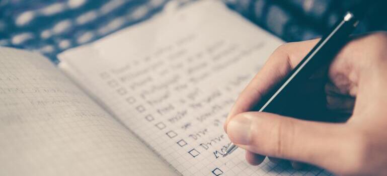 person writing in the notebook to avoid the lack of time to unpack