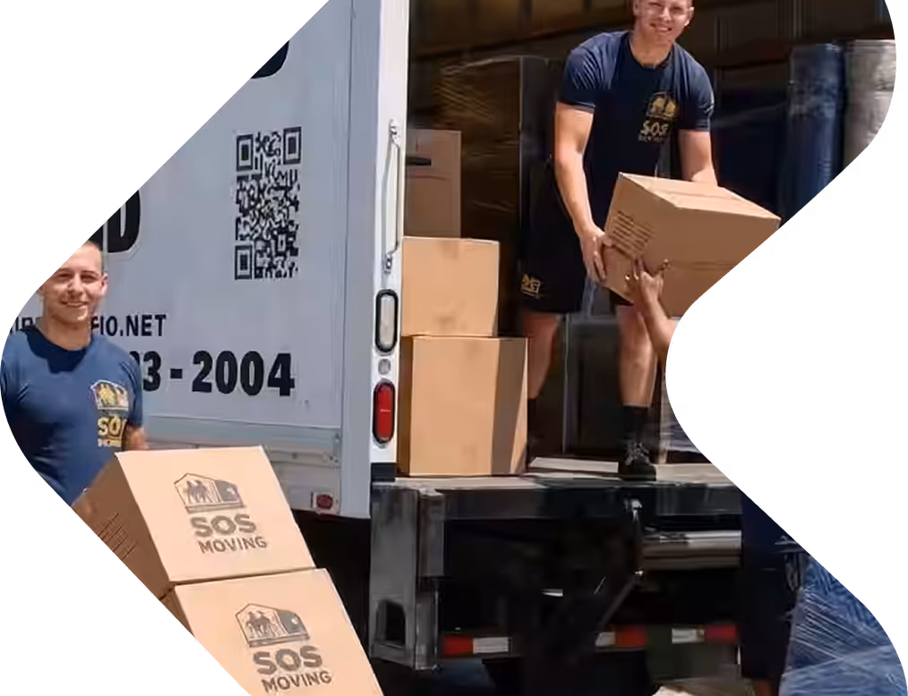 Two movers wearing SOS Moving uniforms loading cardboard boxes into a moving truck.